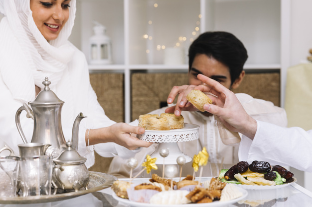 eid-al-fitr-concept-with-people-eating-table_23-2147799467