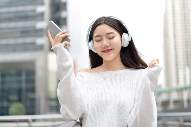asian-girl-wearing-headphones-listening-streaming-music-with-eyes-closed_8087-3741