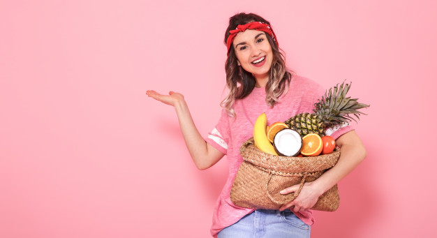portrait-girl-with-bag-with-fruit-isolated-pink-wall_169016-1402