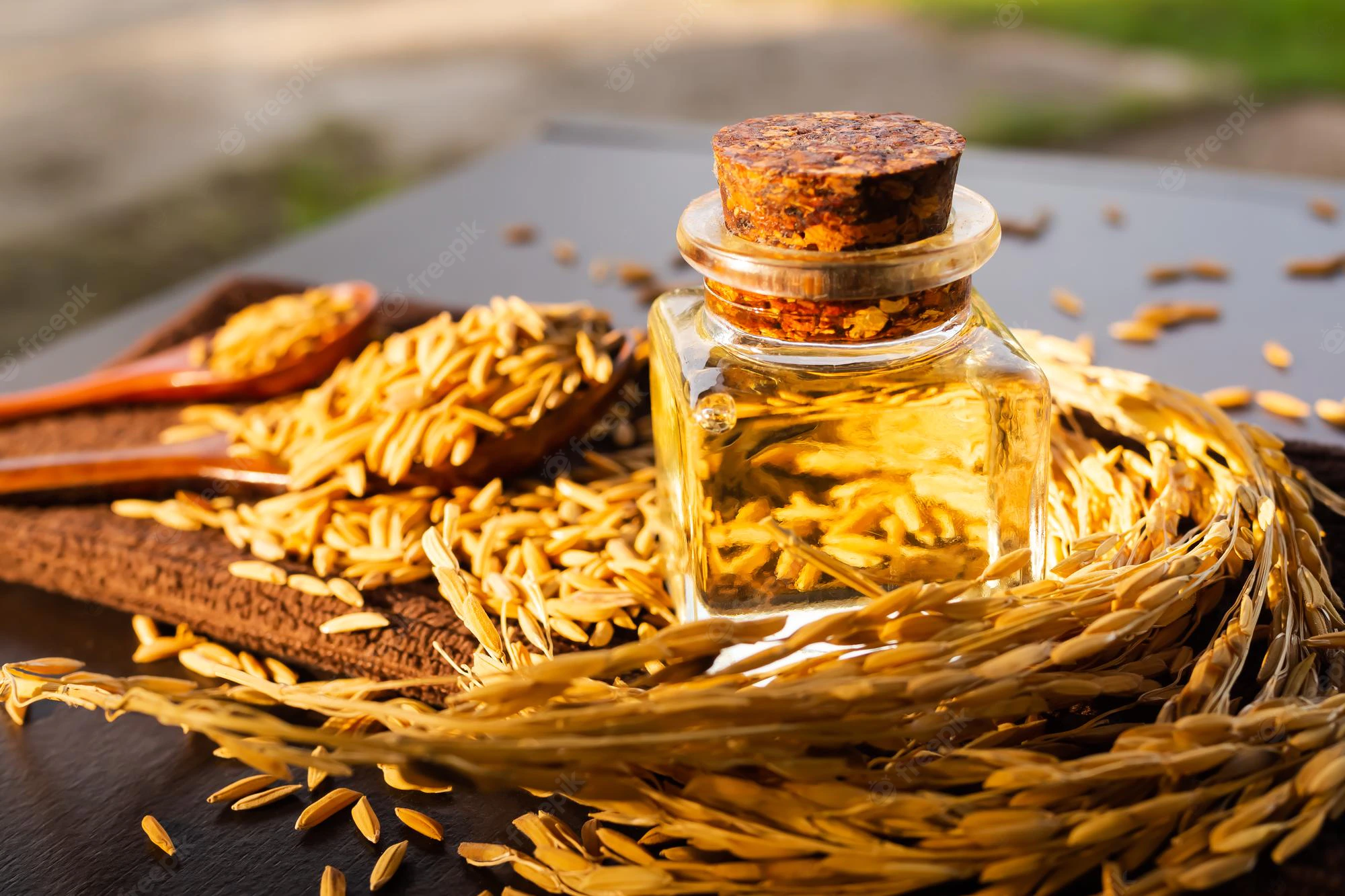 rice-bran-oil-bottle-glass-with-ears-rice-grain-wood-background-top-view-organic-herbal-meal-raw-food-ingredient-good-health_301927-631